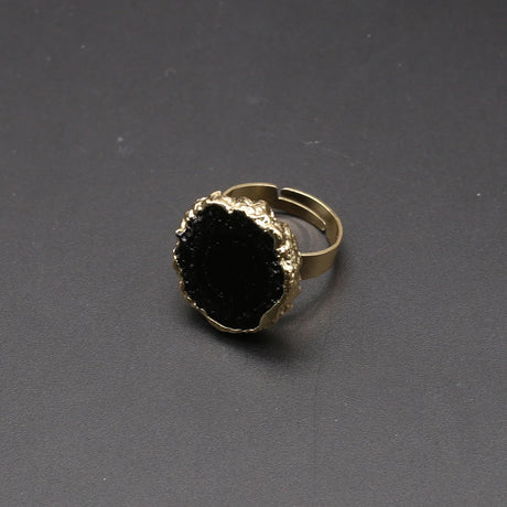 Gold ring with a black gemstone on a gray background