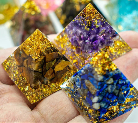 Colorful crystal pyramids held in a hand with 'AierCrystal' branding.
