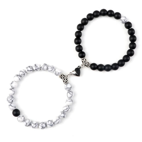 Two bracelets, one with black beads and the other with silver and crystal beads, on a white background.