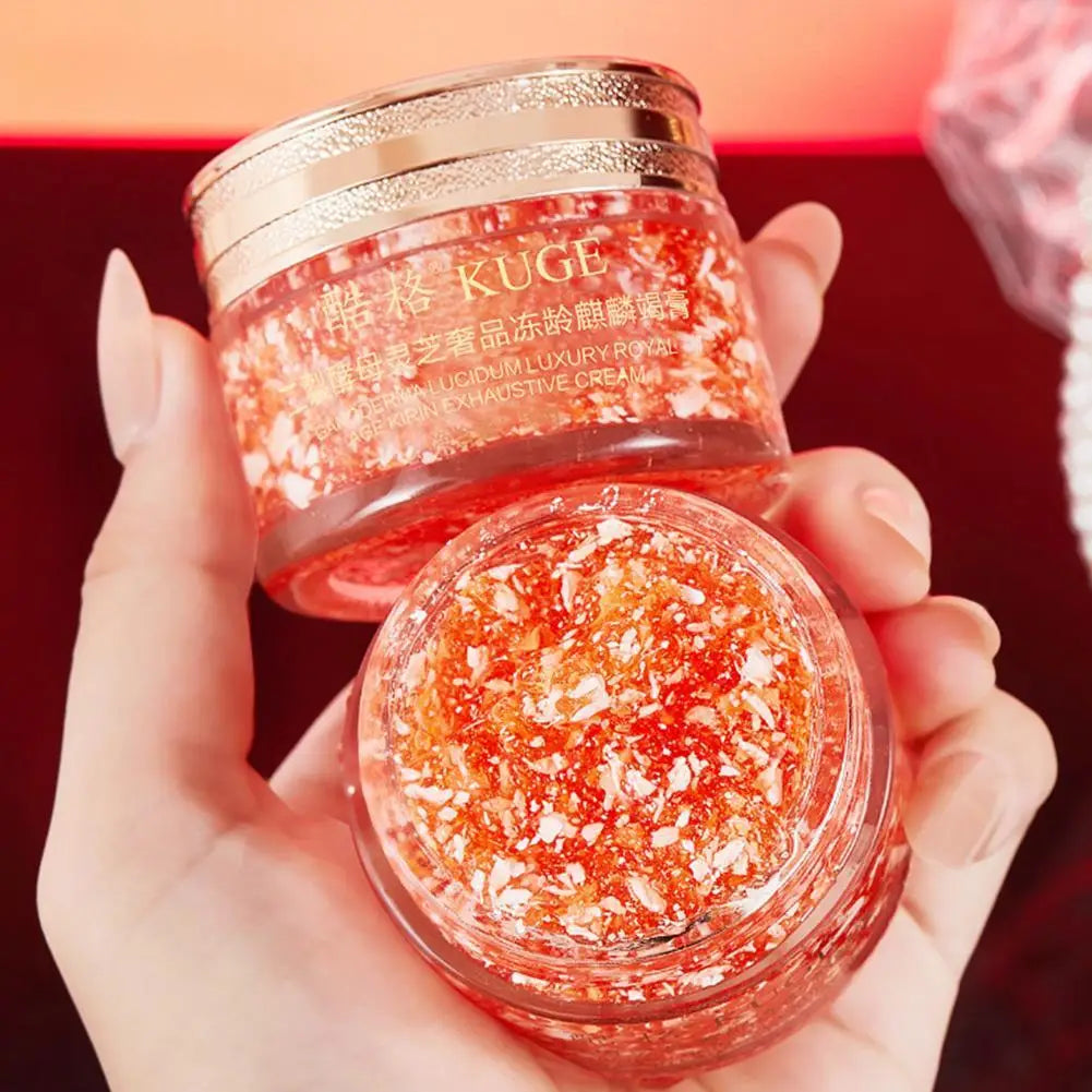 Two jars of KUGE cream held by a hand against a red background