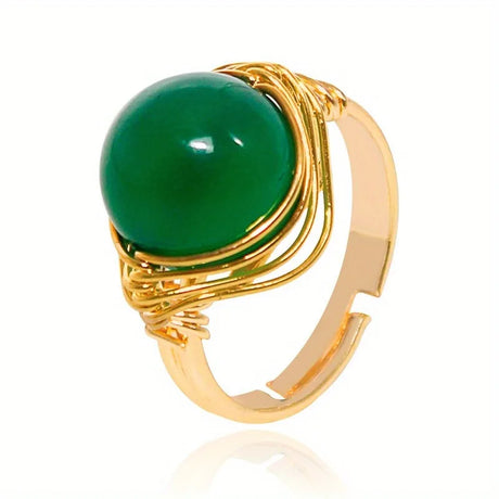 Gold ring with a green gemstone on a white background