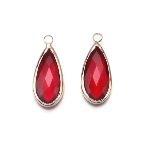 Two red teardrop-shaped pendants with gold frames on a white background