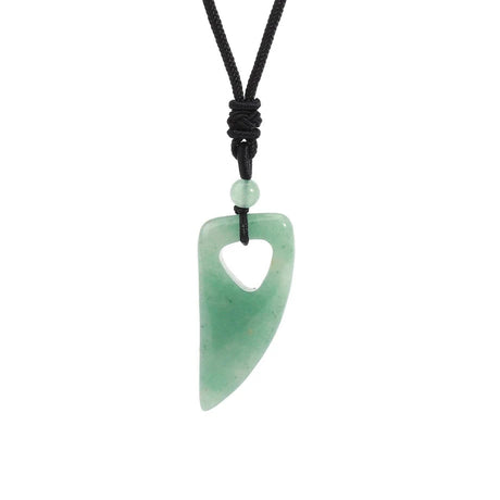 Green jade pendant on a black cord with a white background