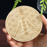 Round wooden coaster with laser-cut design of a woman and floral patterns held by a hand.