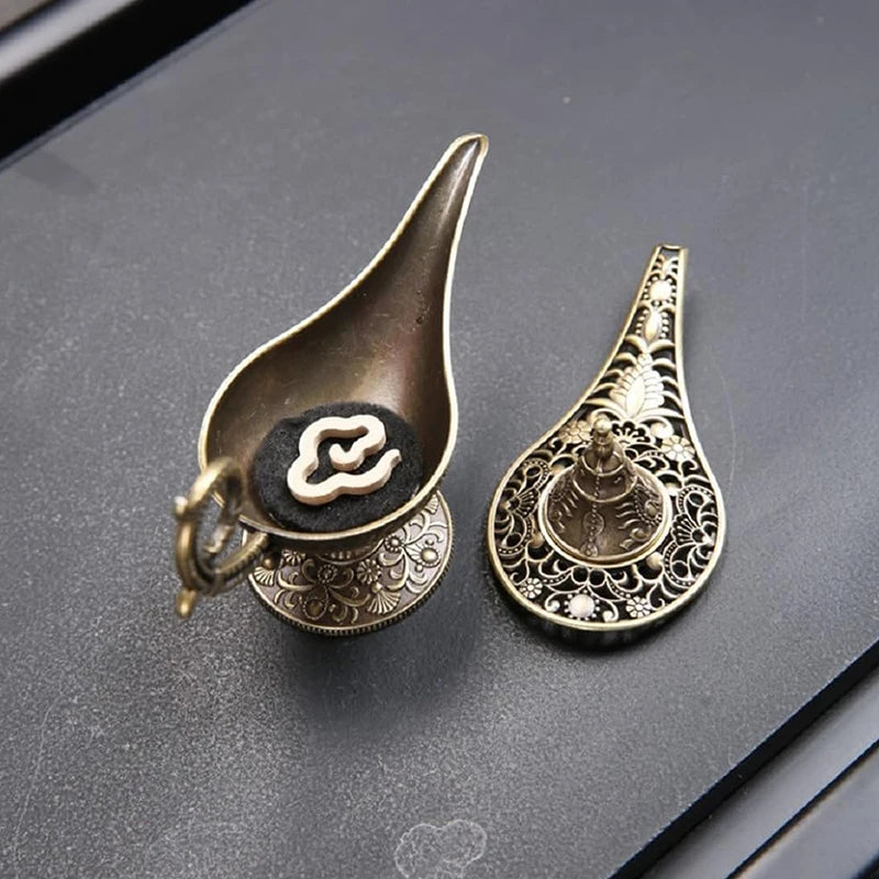Two decorative items resembling Aladdin's lamp on a dark surface
