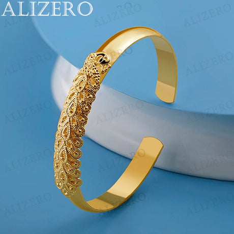 Gold bracelet with intricate design on a blue background, featuring the brand 'ALIZERO'.