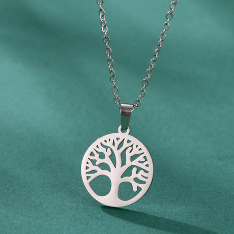 Silver tree-shaped pendant necklace on a green background