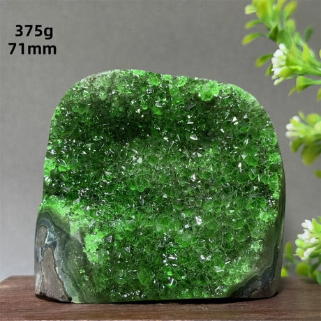 Green crystal rock on a wooden surface with a gray background