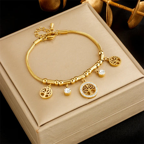 Gold bracelet with charms on a beige box