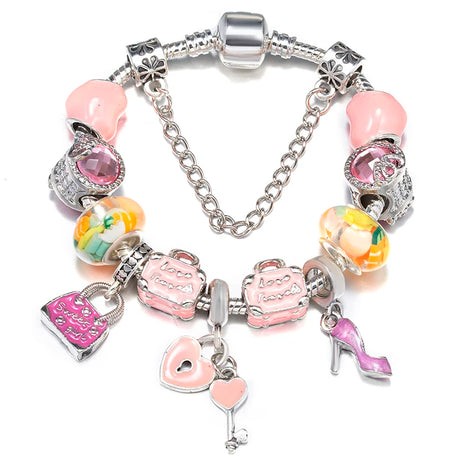 Silver bracelet with various charms including pink hearts, a high heel shoe, and colorful flowers on a white background.