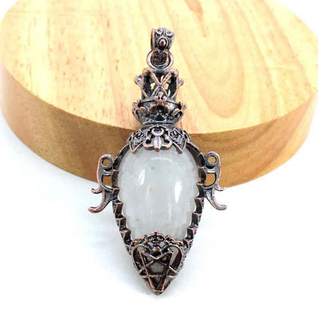 Decorative pendant with a white central stone on a wooden background
