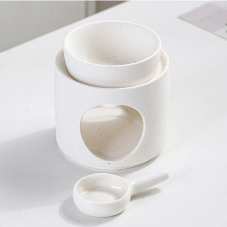 Set of white ceramic bowls and a spoon on a light surface