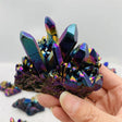 Hand holding a colorful crystal cluster with a white background
