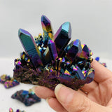 Hand holding a colorful crystal cluster with a white background