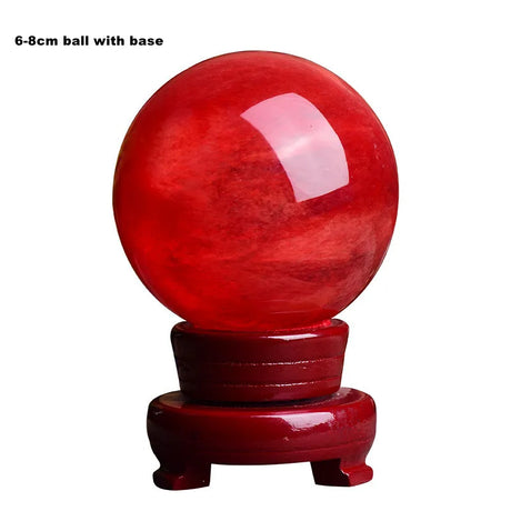 Red crystal ball with a wooden base on a white background