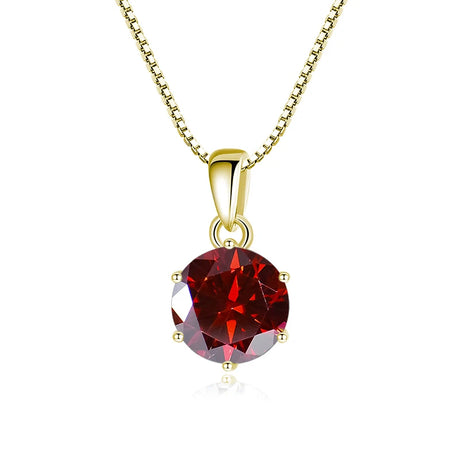 Gold pendant with a red gemstone on a white background