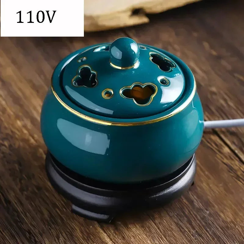 Teal ceramic diffuser with gold accents on a wooden surface, labeled '110V'.