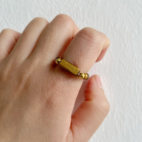 Gold ring on a finger against a white background