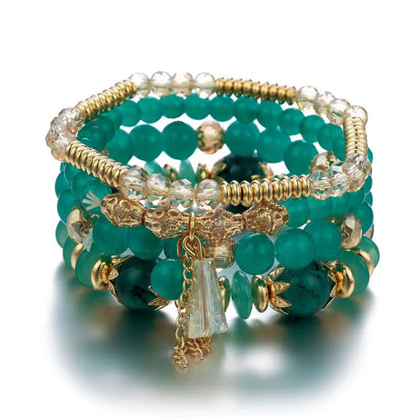Stack of green beaded bracelets with gold accents on a white background
