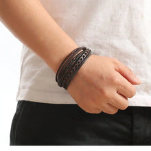 Person wearing a black leather bracelet on a white background