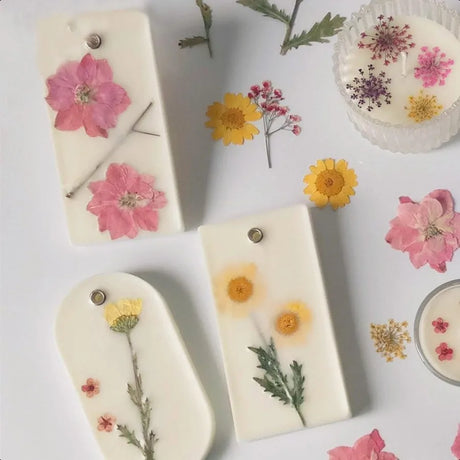 Decorative soaps with pressed flowers on a white background