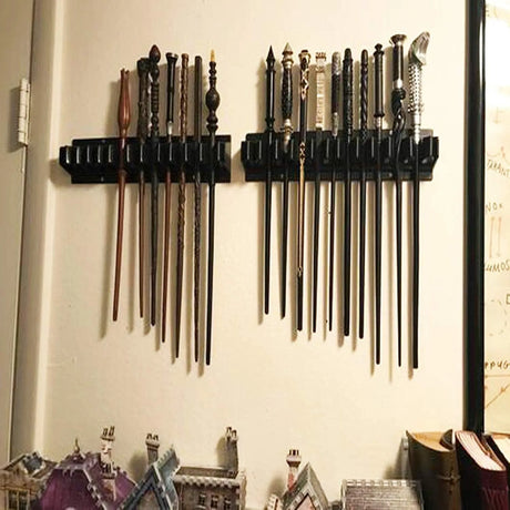 Set of wands displayed on a wall-mounted holder against a light background.