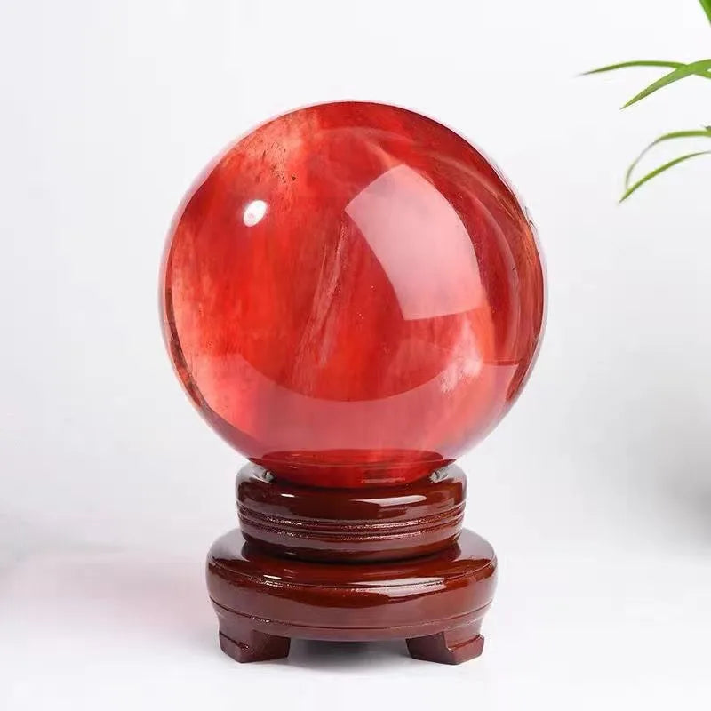 Red crystal ball on a wooden stand with a white background