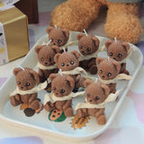 Small brown teddy bears with white scarves on a white tray