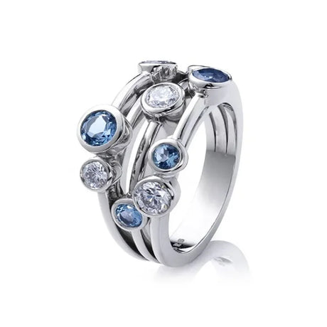 Silver ring with blue and clear gemstones on a white background