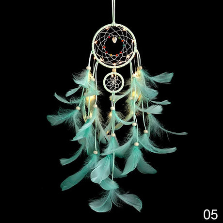 Turquoise feathered dreamcatcher with lights on a black background