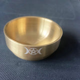 Gold bowl with a symbol on a blue fabric background