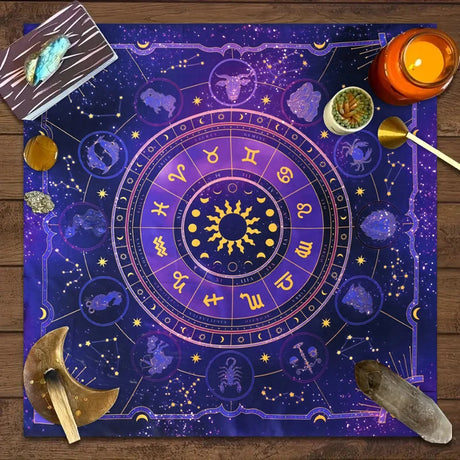 Astrological chart with zodiac symbols on a wooden surface with candles and crystals.