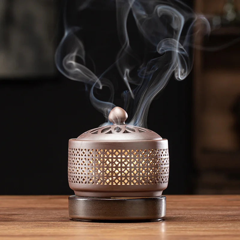 Bronze incense burner with smoke on a wooden surface