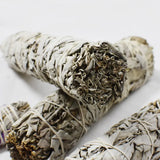 Three sage smudge sticks on a white background