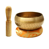 Bronze singing bowl with wooden striker on a white background