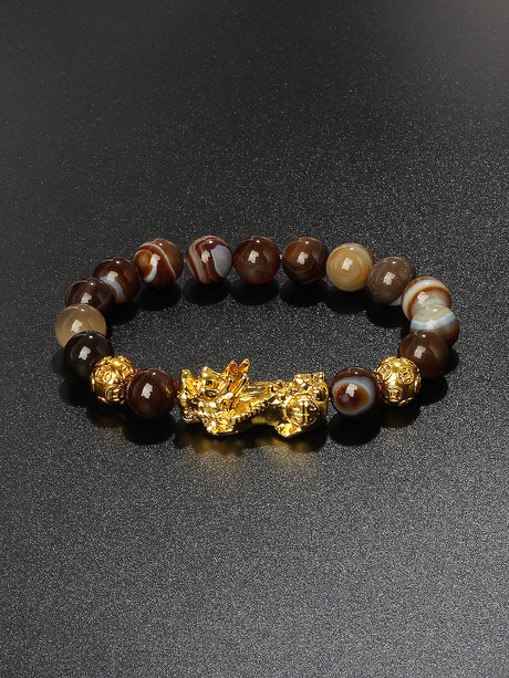 Bracelet with brown and gold beads on a dark background
