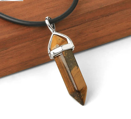 Crystal pendant necklace on a wooden surface with 'C&A' branding.