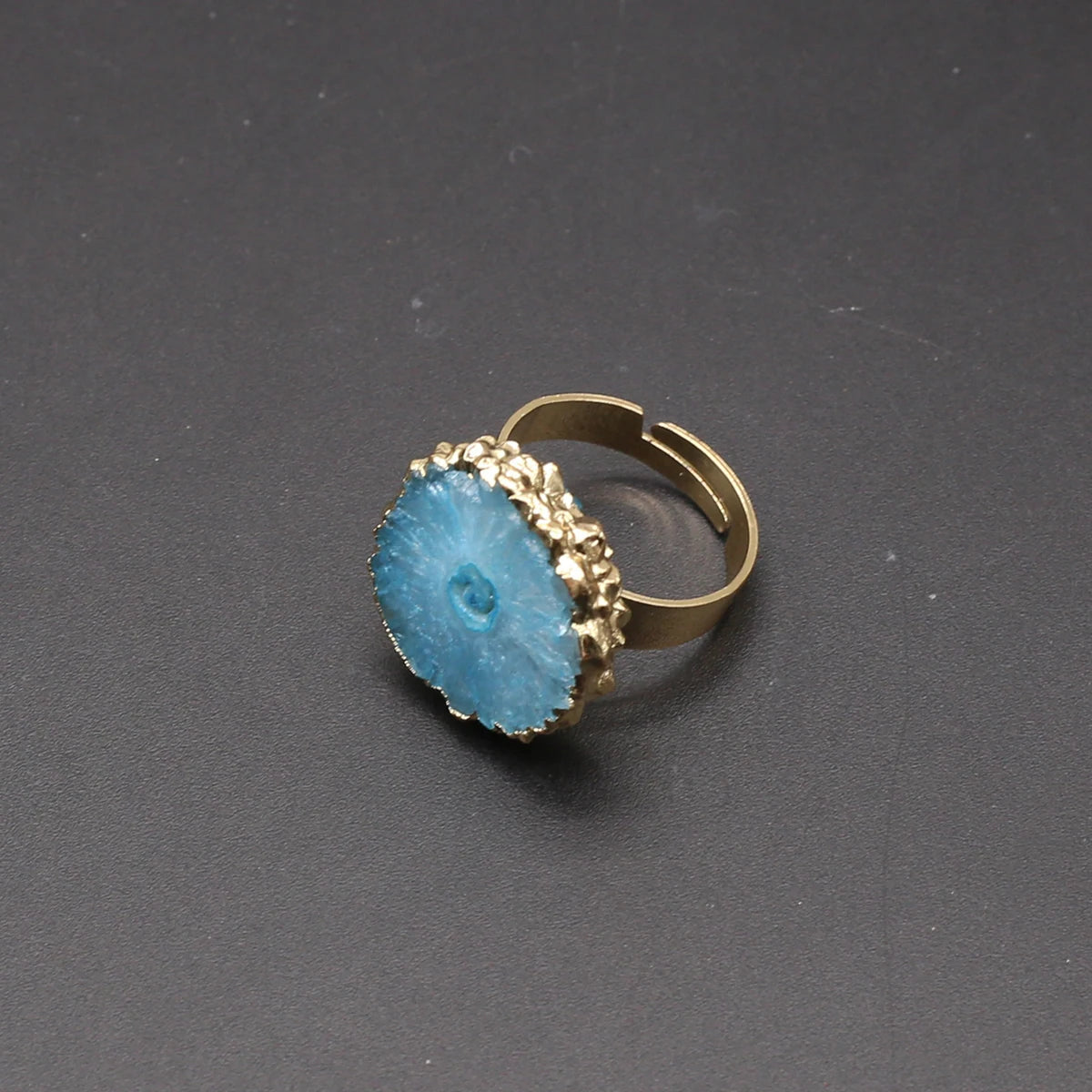 Gold ring with a blue stone on a dark gray background