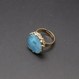 Gold ring with a blue stone on a dark gray background