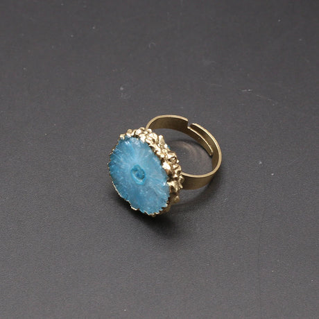 Gold ring with a blue stone on a dark gray background