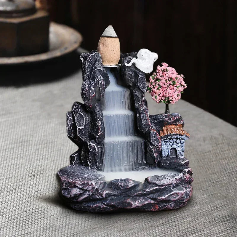 Decorative fountain with a small house and tree on a gray surface