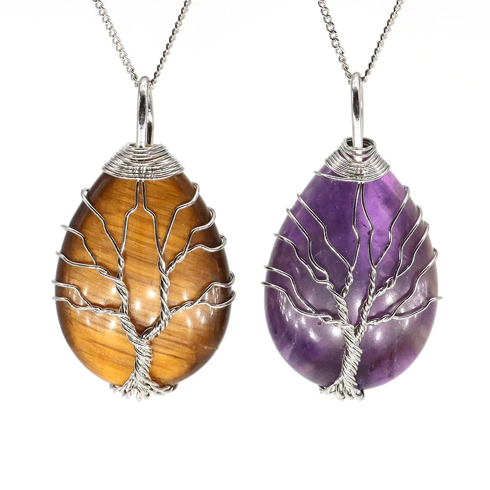 Two tree-shaped stone pendants, one brown and one purple, on silver chains against a white background.