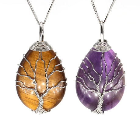 Two tree-shaped stone pendants, one brown and one purple, on silver chains against a white background.