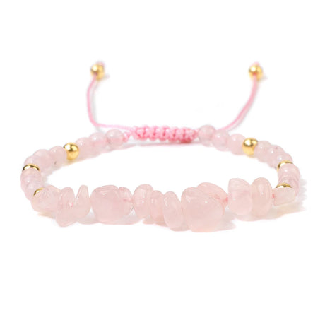 Pink beaded bracelet with gold accents on a white background