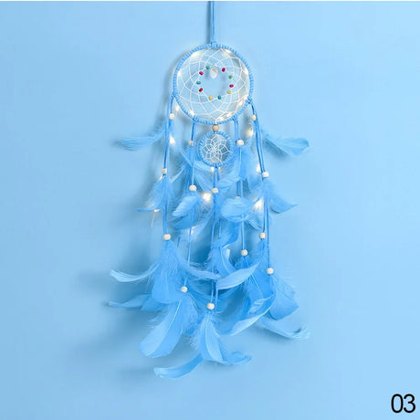 Blue dreamcatcher with feathers and lights on a light blue background