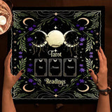 Decorative mat with tarot design held by hands, featuring moon phases and card labels.