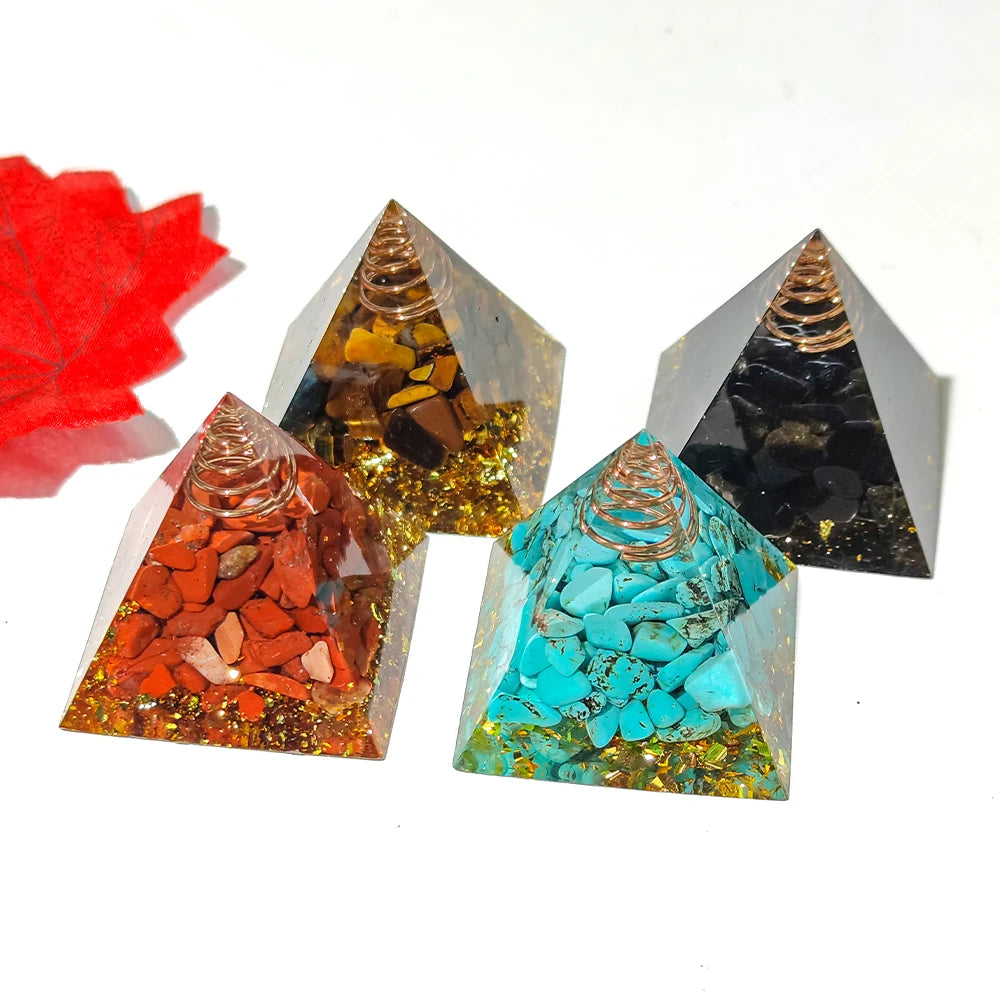 Four pyramid-shaped crystal objects with different colored stones on a white background