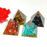 Four pyramid-shaped crystal objects with different colored stones on a white background