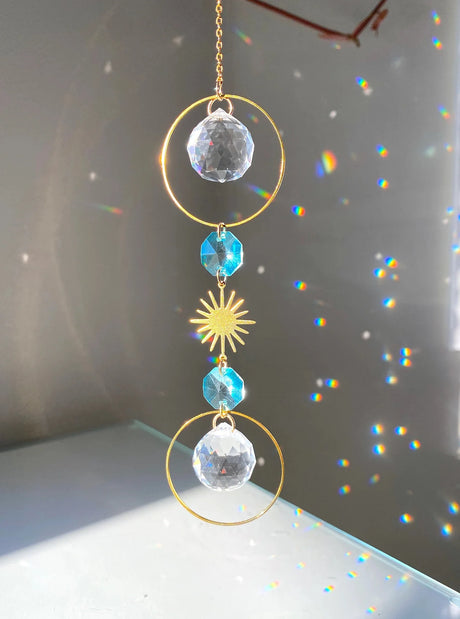 Decorative hanging crystal with sun design on a reflective surface