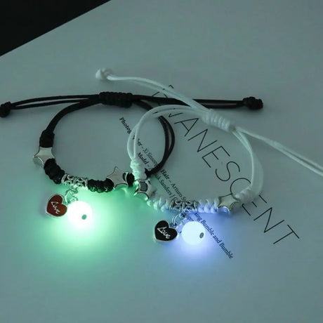 Two glowing bracelets with heart-shaped charms on a white background
